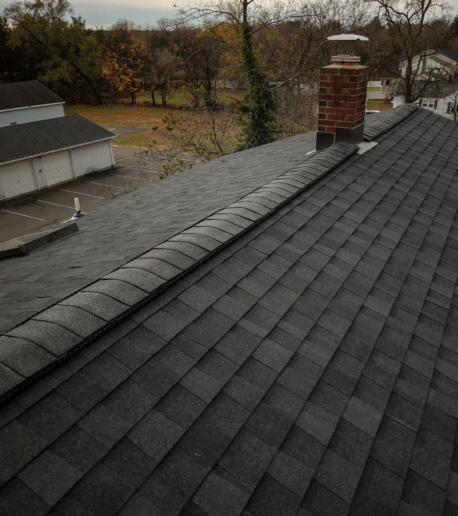 Finished architectural shingle roof with ridge vent after storm restoration
